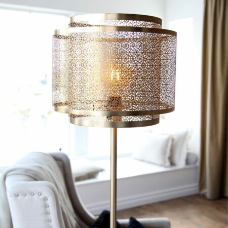 Goldene Vintage-Stehleuchte mit ausgestanztem Lampenschirm im Oriental-Look; im Hintergrund eine Einrichtung im romantischen Vintage-Look